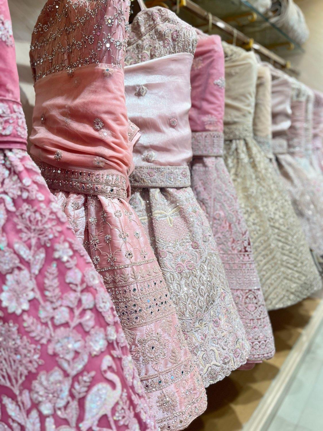 Boutique owner with her collection of suits and lehengas